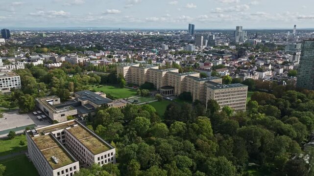 An aerial drone view of Goethe University Frankfurt in Frankfurt, Germany, showcasing the university's modern and historic buildings spread across a vibrant urban campus. 