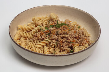 This image shows a bowl of pasta with a hearty meat sauce