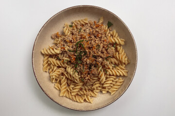 This image shows a bowl of pasta with a hearty meat sauce