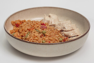 The image shows a delicious-looking meal consisting of a bed of seasoned rice with vegetables, accompanied by slices of cooked chicken.