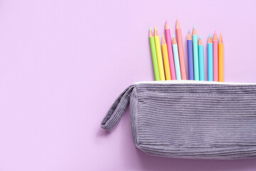 Case with colorful pencils on lilac background, closeup