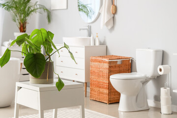 Interior of light bathroom with bathtub and toilet bowl