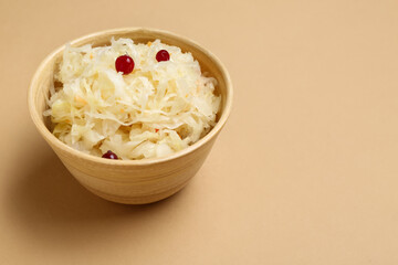 Bowl of tasty sauerkraut on beige background