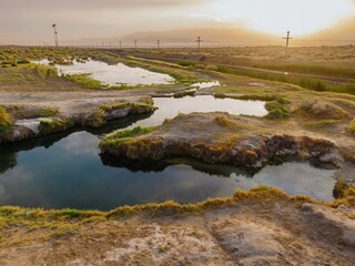 Landscape view of Trego Hot Springs and a mountain in the background, near a railroad track in Nevada, United States. The water is still and reflective. ,Gerlach, Nevada, USA