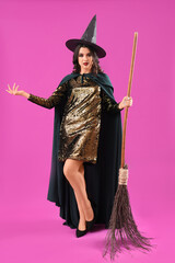 Young witch with broom on purple background