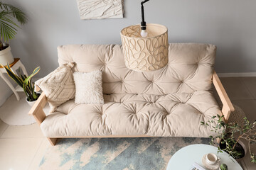 Interior of modern living room with cozy white sofa, coffee table and standard lamp