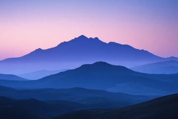 Fototapeta premium Serene sunset silhouettes of layered mountains in shades of blue and purple, a tranquil landscape.