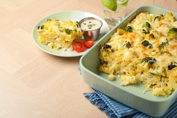 Tasty pasta casserole with cheese and broccoli served on wooden table, closeup. Space for text
