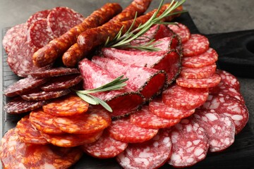Different smoked sausages slices served on grey table, closeup