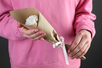 Woman with beautiful flower shaped candle on black background, closeup