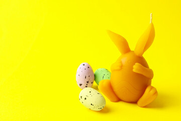 Beautiful candle and candies on yellow background, closeup with space for text. Easter decor