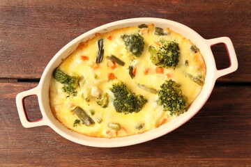 Delicious vegetable casserole on wooden table, top view