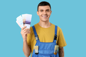 Young painter with color palettes on blue background