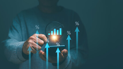 Finance and business growth concept. Businessman holding magnifying glass with graph for analyte growing project performance. Percentage of financial increase interest rate or investment dividend.