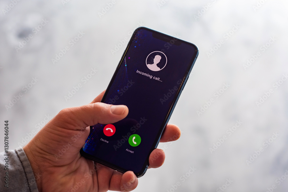 Poster close-up of a hand holding a smartphone with an incoming call screen. display shows incoming call wi