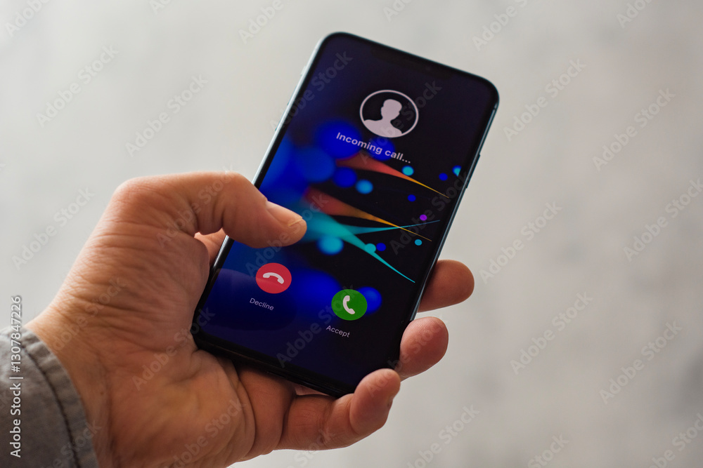 Poster close-up of a hand holding a smartphone with an incoming call screen. display shows incoming call wi