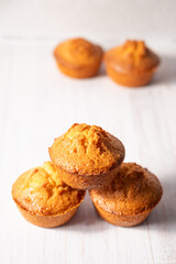 home baked lemon muffins on off white background