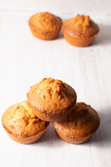 home baked lemon muffins on off white background