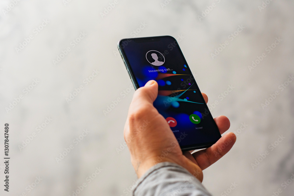 Poster close-up of a hand holding a smartphone with an incoming call screen. display shows incoming call wi