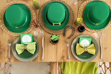 Festive table serving with leprechaun's hats, horseshoe and clovers, top view. St. Patrick's Day...
