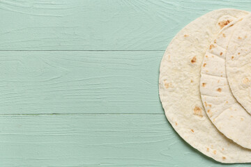 Tasty thin lavash on green wooden background