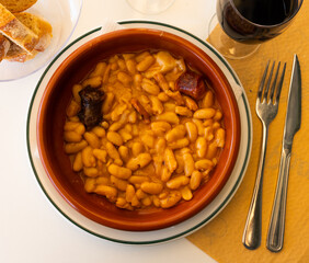 Traditional Asturian rich beans stew Fabada with pork shoulder, morcilla and chorizo served in clay...
