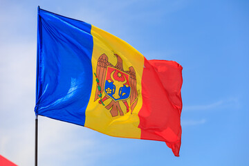 Flag of the Republic of Moldova Waving Against Blue Sky