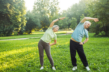 Yoga at park. Senior family couple exercising outdoors.