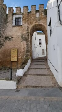 View of the Puerta de Sancho IV, next to the Mayorazgo tower, a picturesque spot in Vejer de la Frontera, a beautiful white village in the province of Cadiz, Andalusia, Spain.