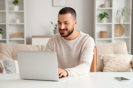 Handsome man working with laptop at home