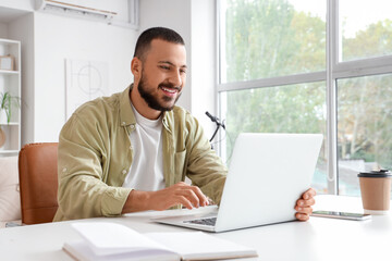 Handsome man working with laptop at home
