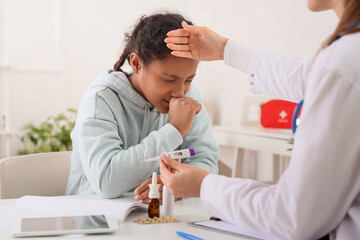African-American teenage girl coughing in doctor's office