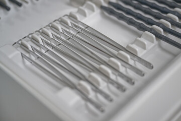 A close-up view of a set of surgical instruments neatly arranged in a tray. The instruments include...