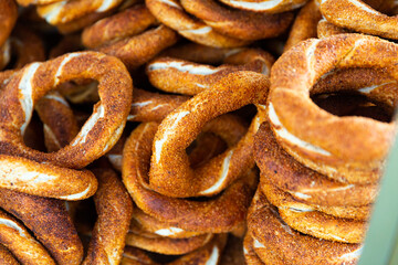 Freshly baked turkish simits, bagels sprinkled with sesame seeds behind glass showcase. Traditional halal food