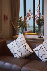 Comfortable sectional sofa adorned with various  white striped throw pillows. Contemporary home with furniture. Pillows on sofa. Artistic and comfortable elements in beautifully decorated hotel lobby.