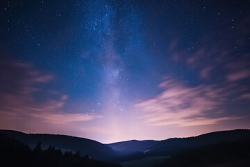 Stunning milky way galaxy shining over mountain valley at night