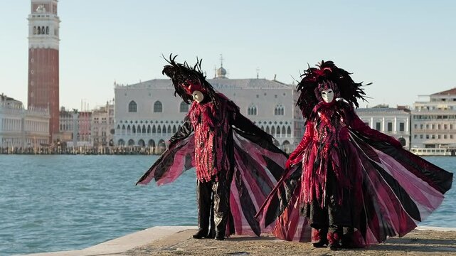 Venice, Italy - People dressed in carnival masks are photographed by tourists in the scenery of the ancient Venetian palaces