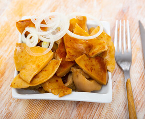 Appetizing sliced russula delica, sprinkled with onions on top