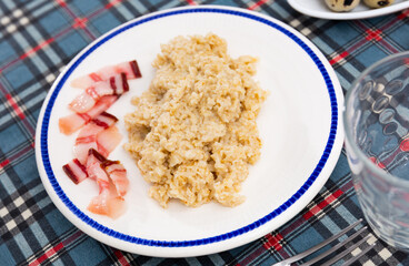 Appetizing lard with hot oatmeal and parsley. Hearty healthy dish