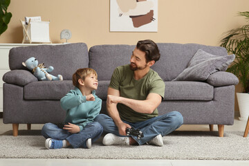 Dad and little son making fist bump gesture at home. Father's day