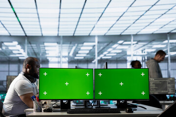 Multi monitor isolated screen computers in data center used by IT employees for supervising server rows in computer network security data center, overseeing supercomputers