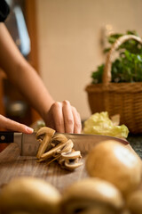 Close-Up of Hands Slicing Mushrooms on Wooden Cutting Board