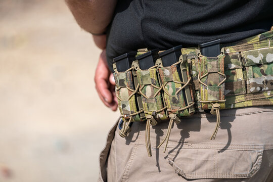 Camouflage tactical belt with handgun magazines at a shooting range, California