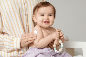 Fototapeta premium Mother applying cream on her little baby's hand on changing table in bedroom. Closeup