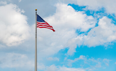 American Flag for Memorial Day or 4th of July. American flag waving in the wind. Flag of the USA. National waving flag of united states on blue sky. Independence day. Patriotic symbol