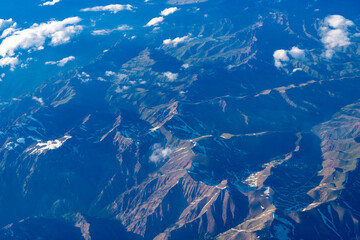 Aerial view of mountain landscape. Aerial cloudy view. Landscape from plane. Top of mountain in cloud. Landscape with mountain in cloudy nature. Cloud and mountain peak aerial view