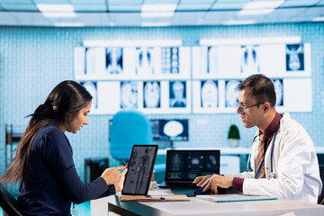 Professional doctor and patient engage in a medical consultation for a scan interpretation of x ray and MRI results. General practitioner emphasizing healthcare practices and medical research.