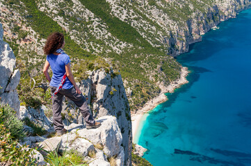 Naklejka premium girl on a cliff of Baunei Coast, Sardinia