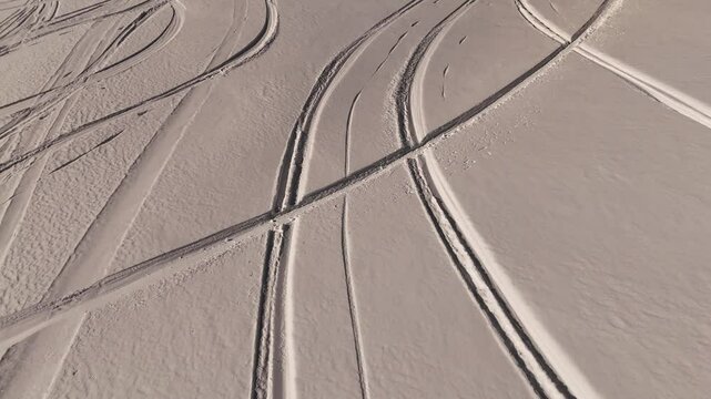 Horizontal dynamic video from drone of winter landscape, tracks of cars and skiers are visible on the white snow, in background UNESCO heritage - huge Italian Alps Dolomites mountains, Sassolungo