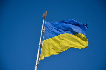 Ukrainian flag waving proudly against a clear blue sky. The vibrant blue and yellow colors stand out boldly, symbolizing the countrys spirit and resilience